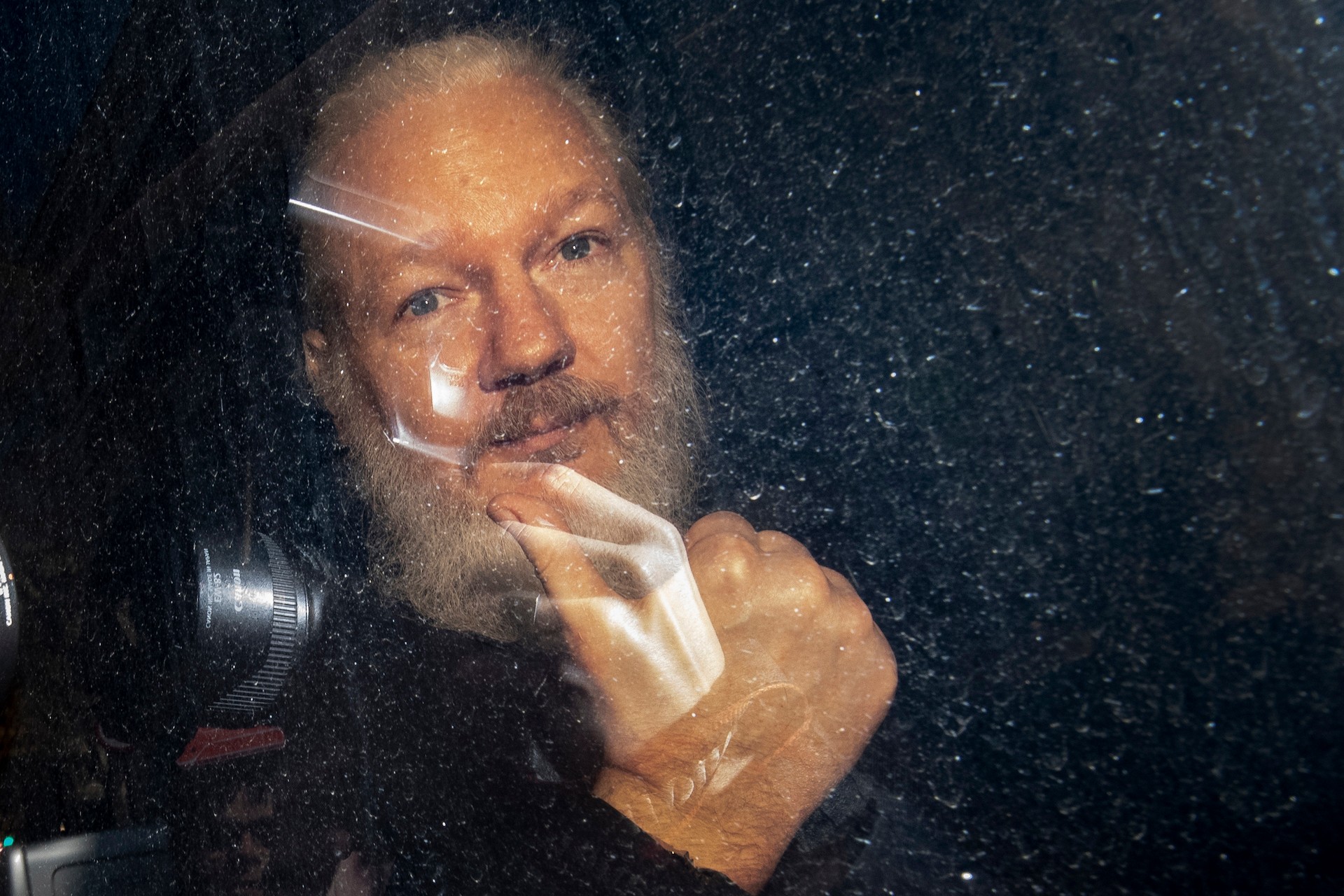 Julian Assange Beams in from Prison for his First Extradition Hearing