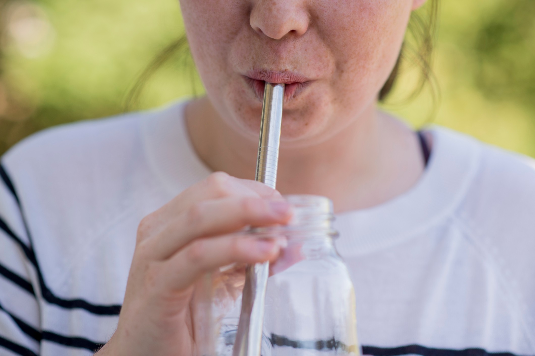 Replacing plastic drinking straws with metal straw concept. Woman