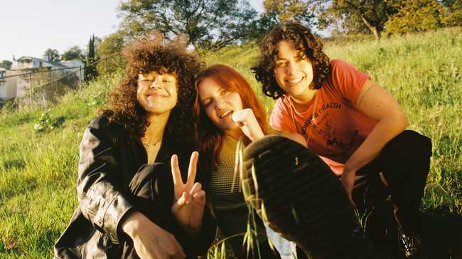 MUNA sitting in a field