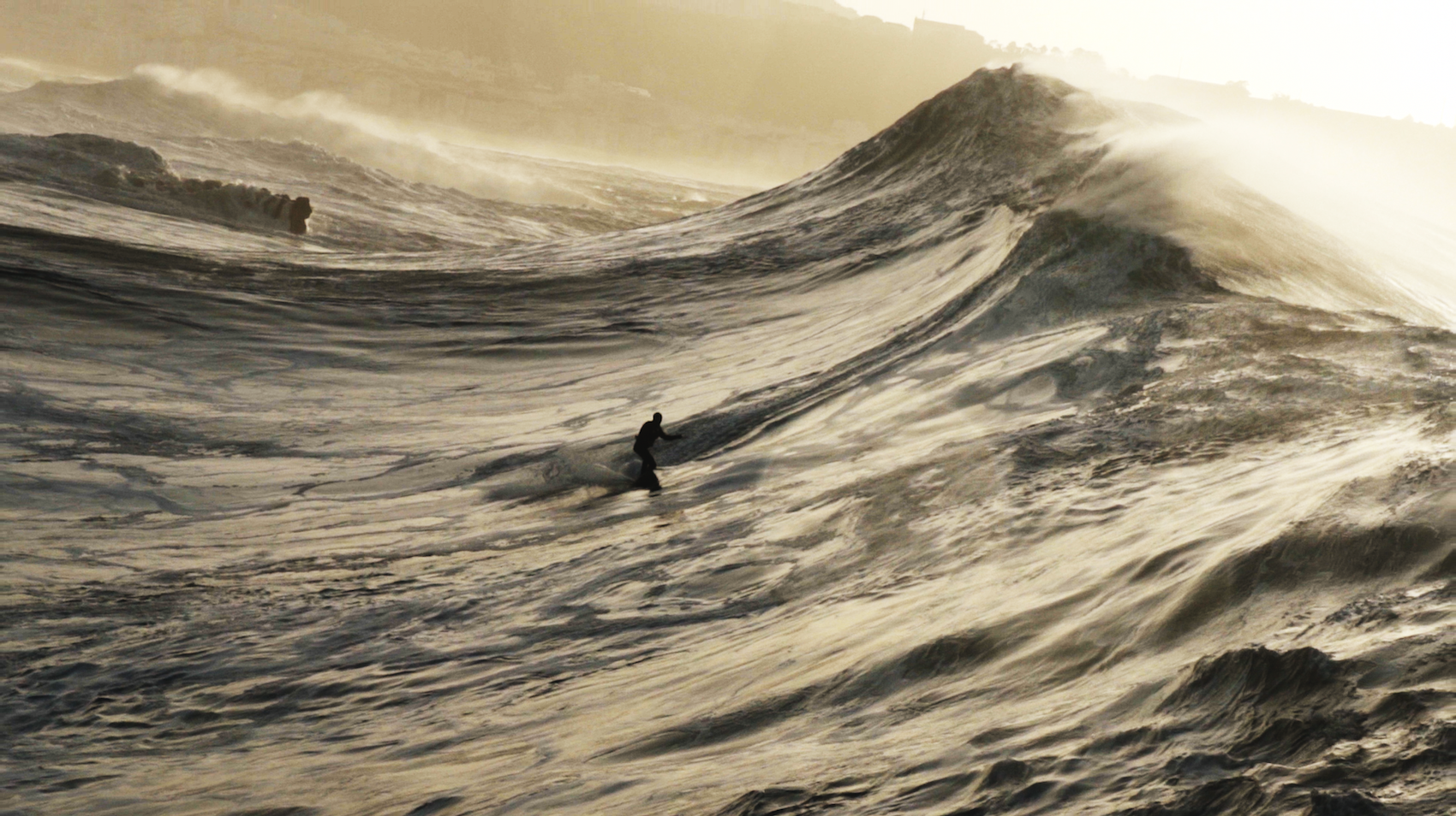 Ein Surfer in den Wellen von Nazaré