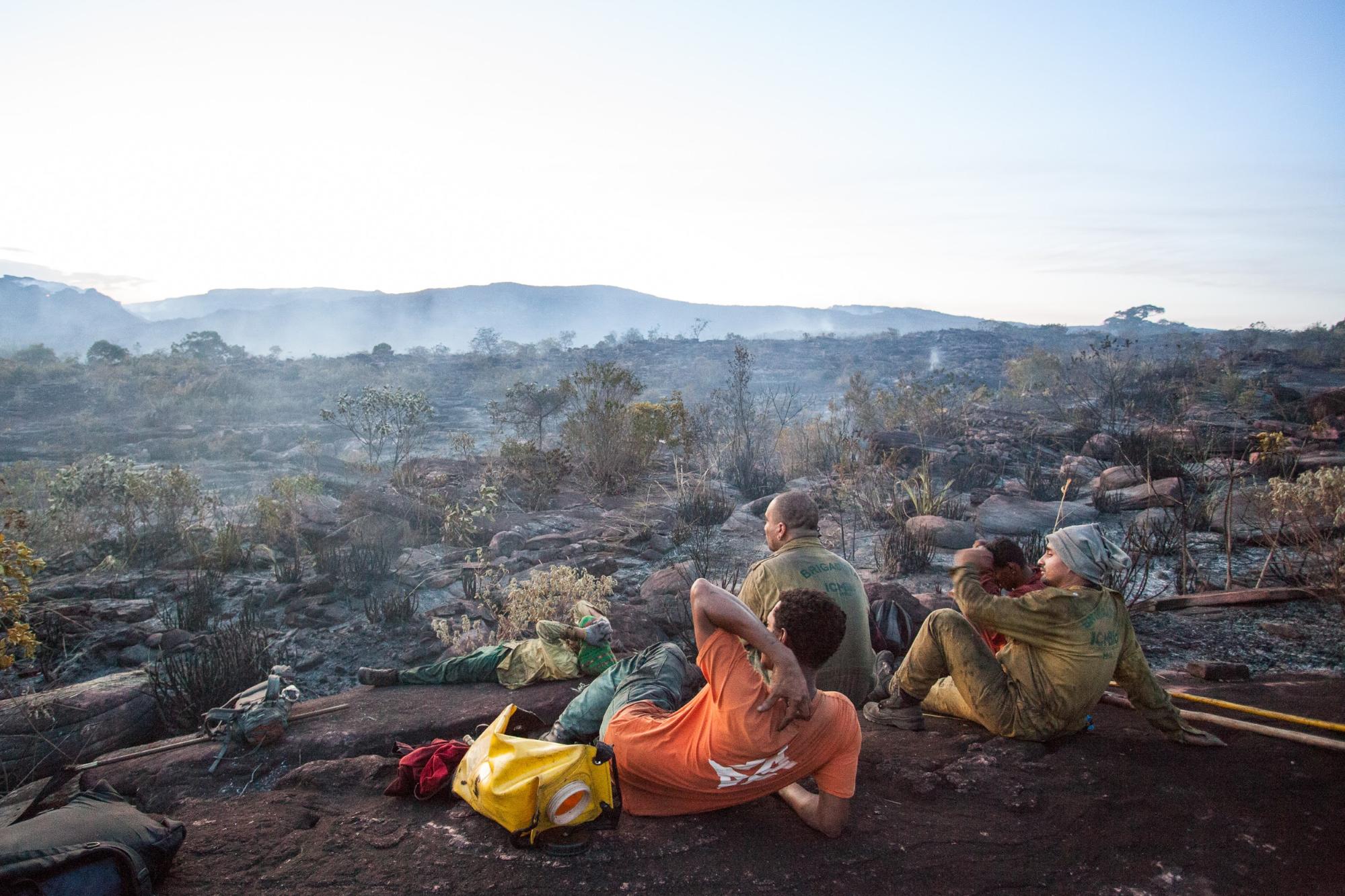 Brigadistas take a break after putting out a fire, waiting to see whether it will start up again. Photo by Açony Santos