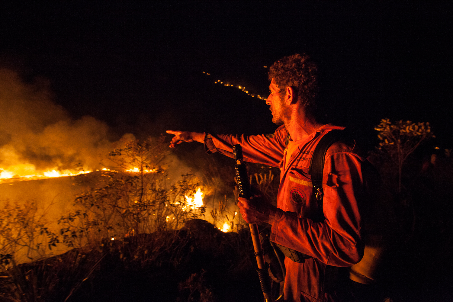 Mel Alves Sena’s brother Cinho points to a line of fire in December 2015 that he ended up fighting the entire night. Photo by Açony Santos