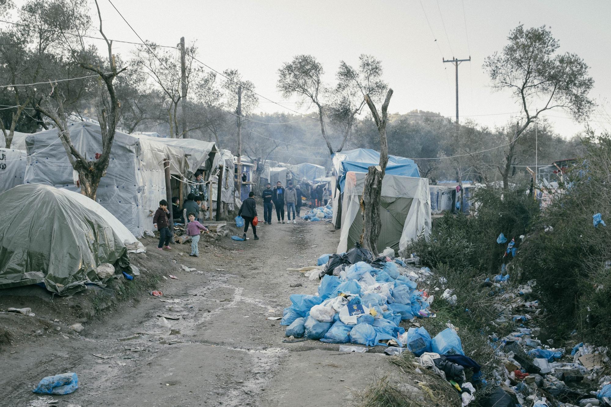 Ein Straße am Camp, an der Seite stapeln sich die Müllsäcke