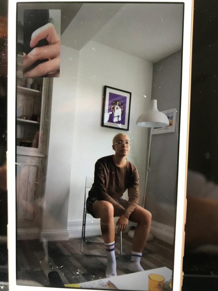 Glazzard's photo of a person sitting on a chair in their apartment, not wearing trousers, it is among the uplifting LGBT+ news headlines during COVID-19