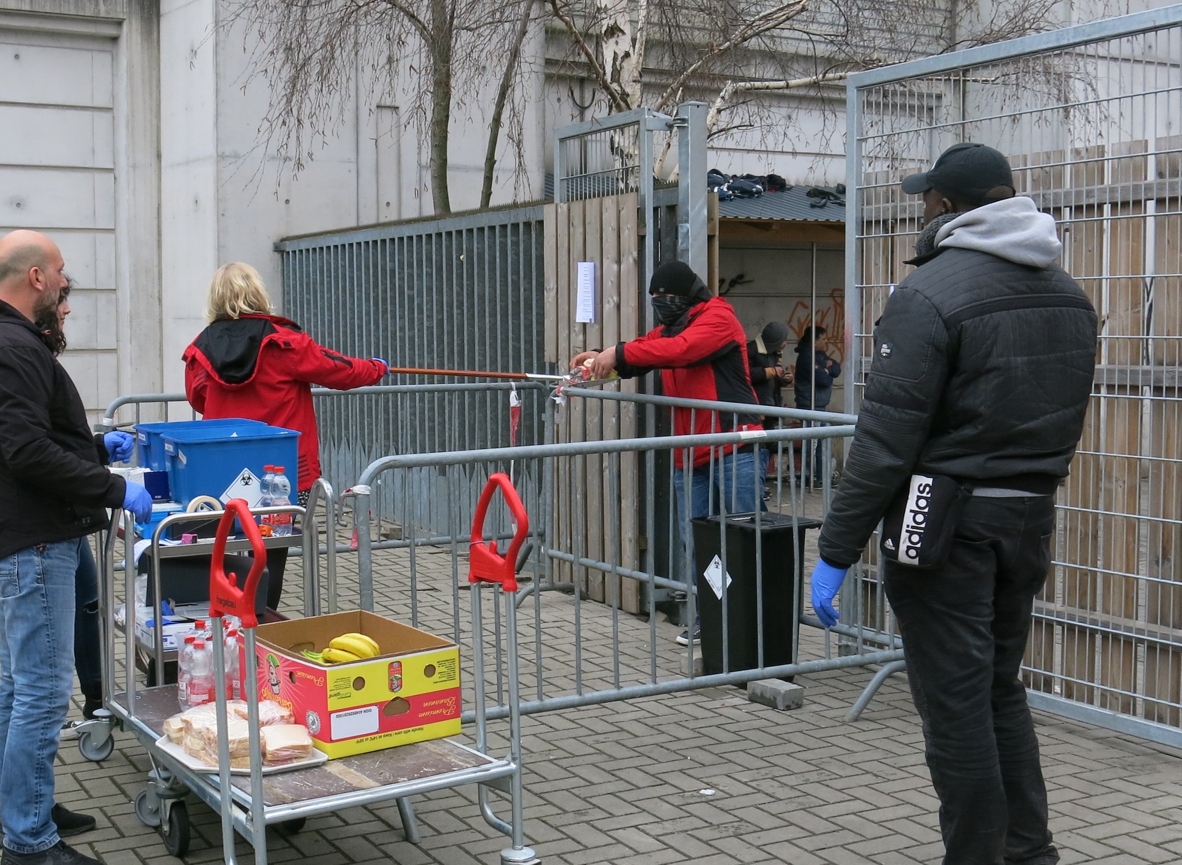 Eine Sozialarbeiterin vom Drogenkonsumraum Stellwerk in Hannover reicht Konsumutensilien und Essen auf einer Schaufel zu einem Mann
