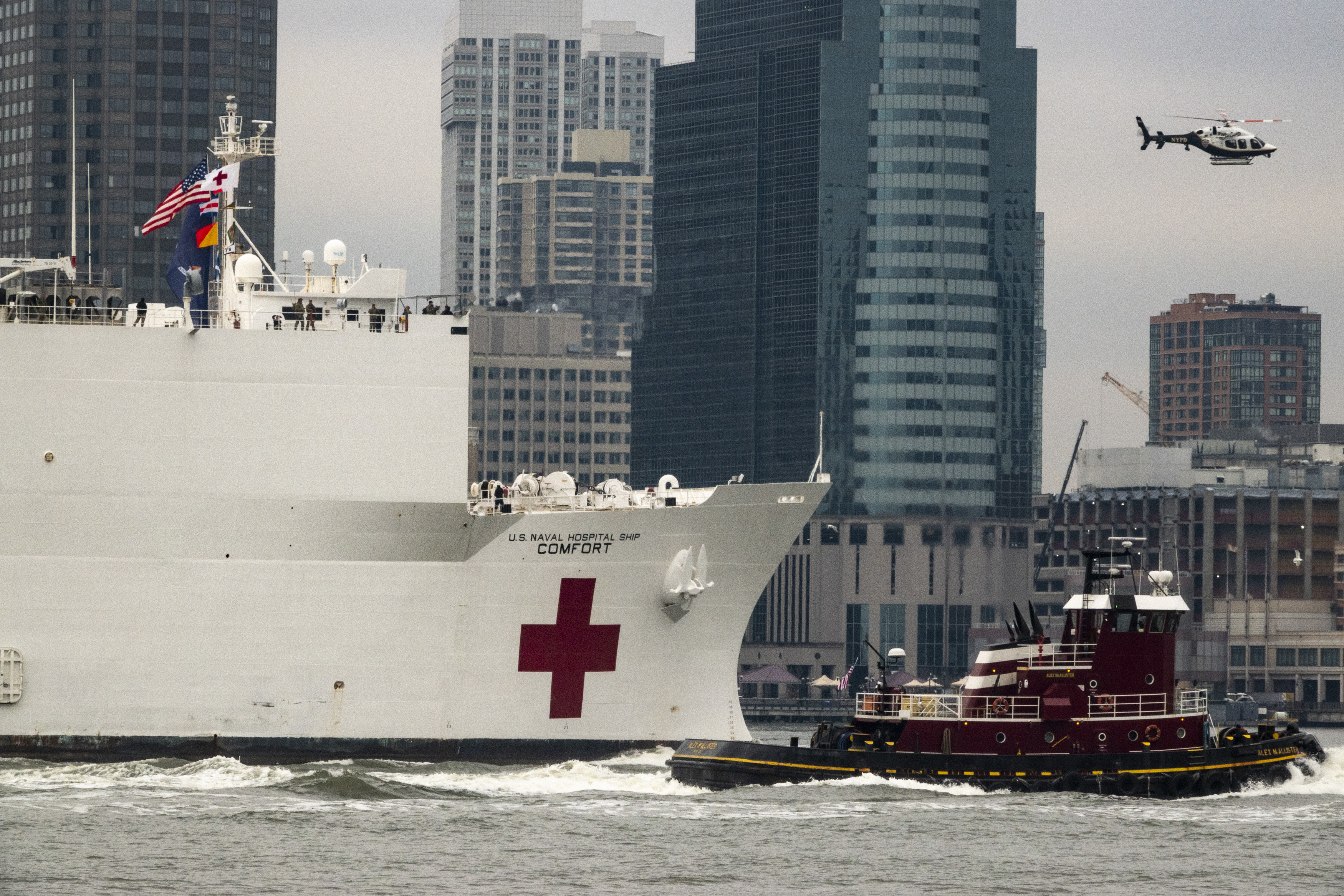 The United States Naval Ship Comfort is guided up the Hudson river with Newark New Jersey seen in the background. March 30, 2020