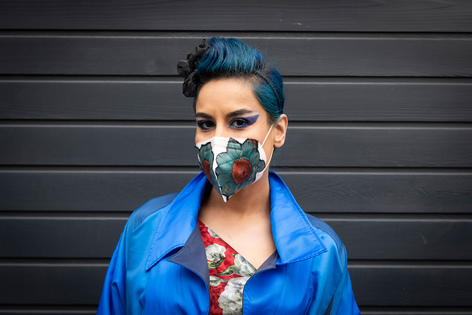 Eine Frau trägt eine professionell genähte Maske mit Blumenmuster