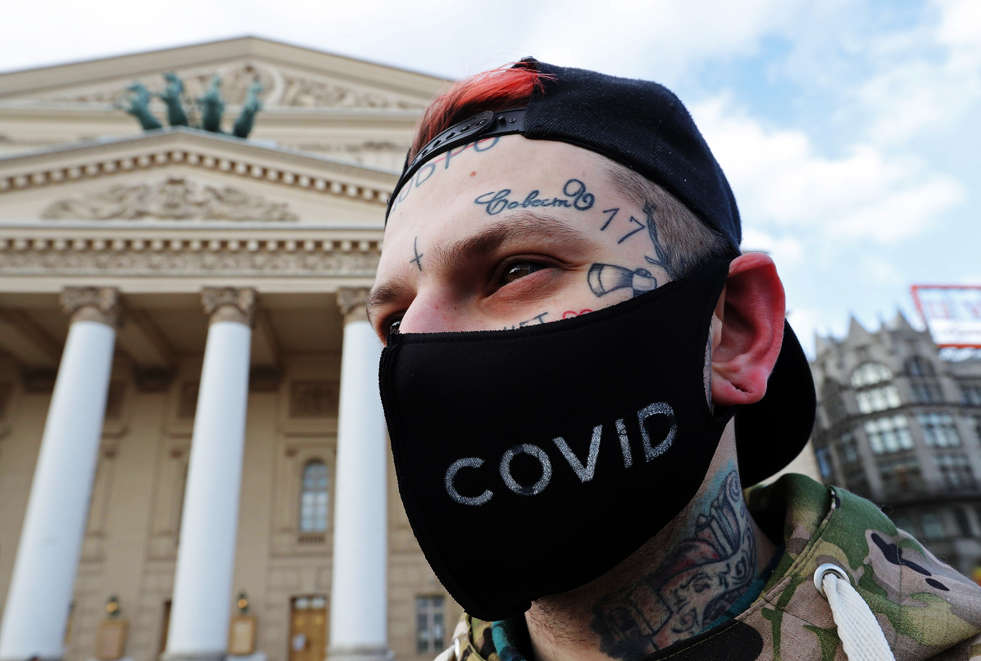 Ein Mann mit Tattoos im Gesicht und einer schwarzen Atemschutzmaske aus Stoff